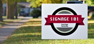 plastic yard sign with 'Signage 101' logo in a grass field