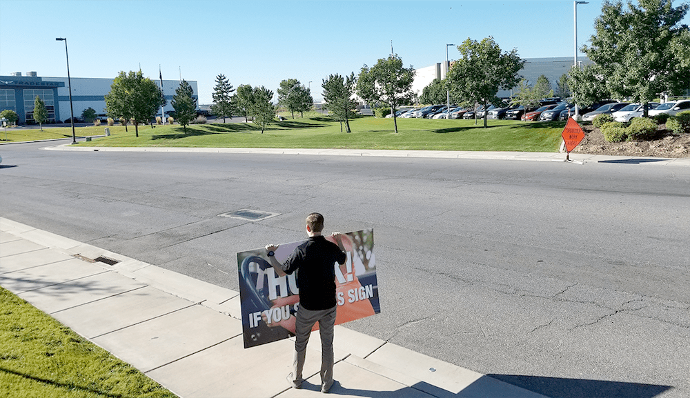 Image of man holding sign with empty street.