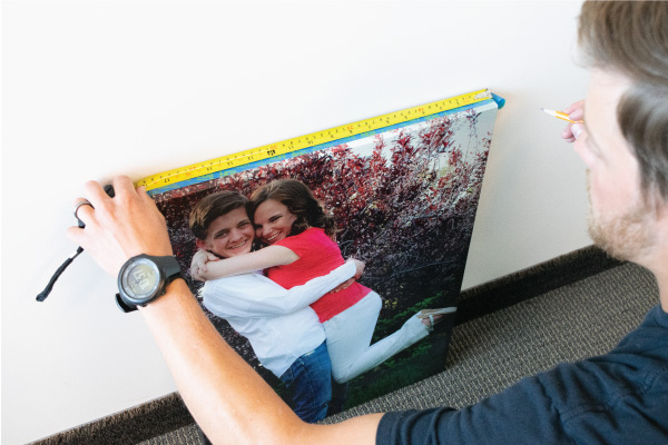 Painters tape on canvas print being measured and marked.