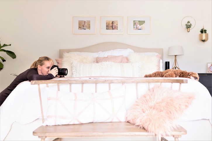 Jen Frase taking a photo of a dog lying on a bed