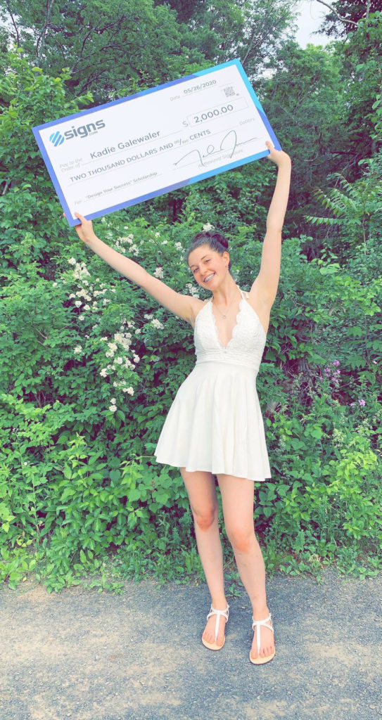 Kadie Galewaler poses with her awarded scholarship Giant Check